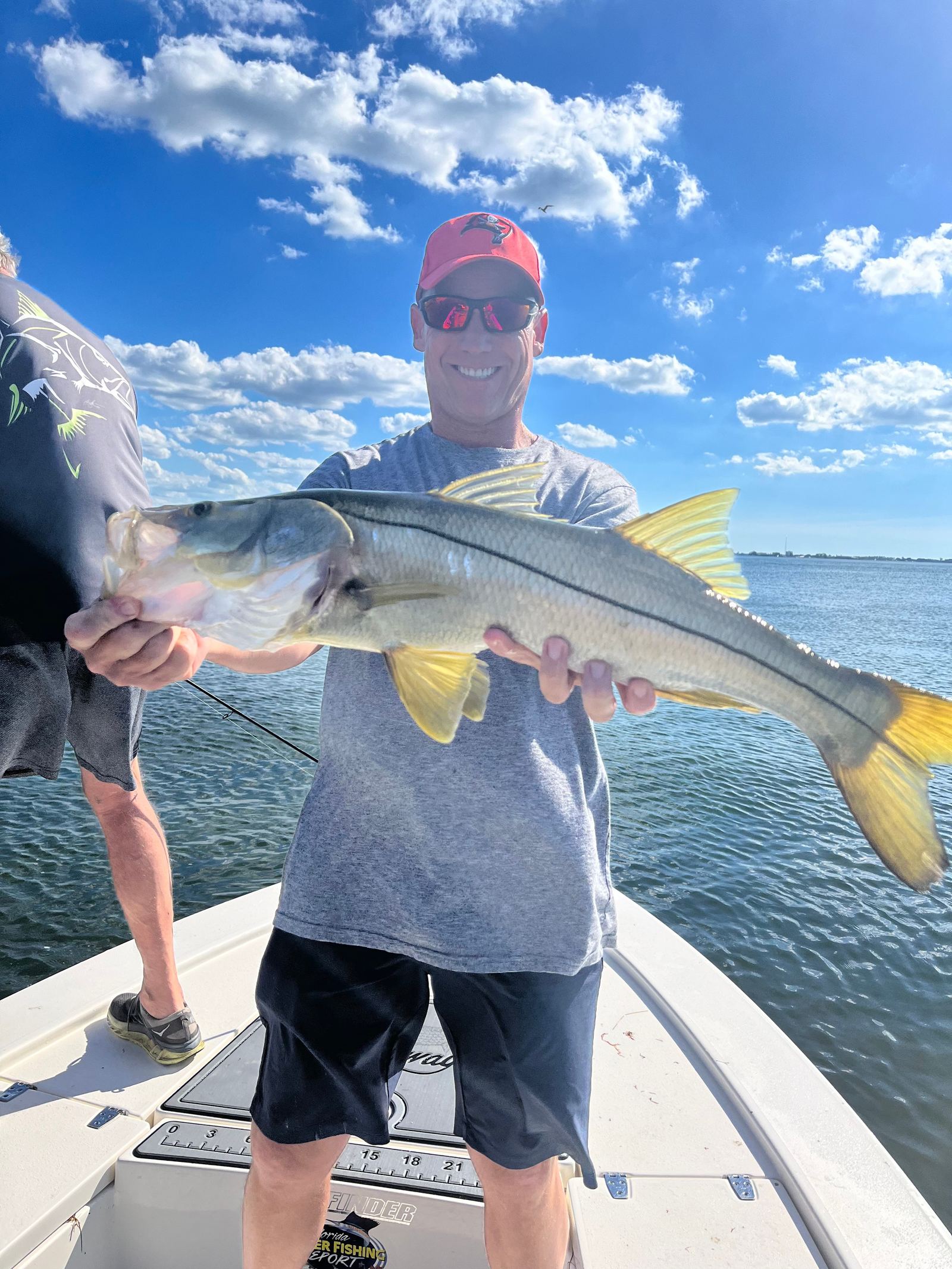 A slot snook measured boat-side against the bay