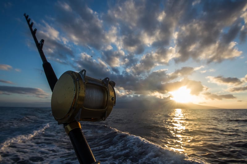 Rod and reel on the rail at sunrise, running out for a Gulf bottom trip